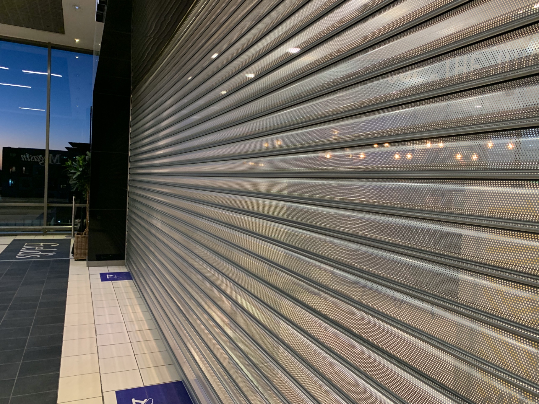 Perforeret rullegitter foran Magasin Fields facade